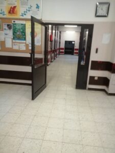 fragment hallu szkoły wraz z drzwiami prowadzącymi na korytarz