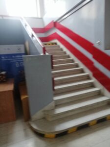 schody wewnątrz budynku z czerwoną poręczą