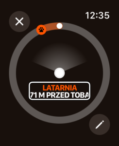 czarny ekran apple watch, na nim tarcza latarni, napis latarnia 71 metrów przed tobą, w prawym górnym rogu godzina