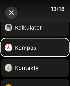 czarny ekran ekranu apple watch, na nim lista aplikacji, które można ustawić na komplikacji: od góry kalkulator, kompas (zaznaczone), kontakty