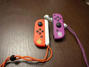 Na fotografii znajdują się kontrolery Joy-con z dołączonymi opaskami na nadgarstek