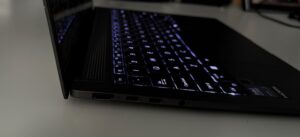 Zbliżenie na lewy bok ultrabooka Asus Zenbook S14. Kolejno od lewej porty HDMI, dwa USB typu C i gniazdo słuchawkowe. Uwagę zwraca niewielka grubość laptopa.