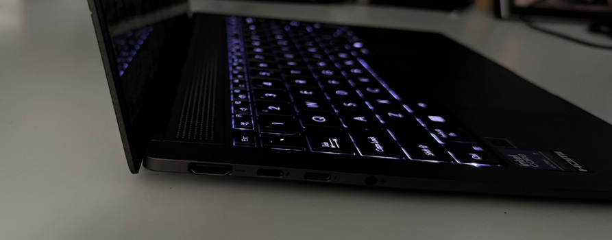 Zbliżenie na lewy bok ultrabooka Asus Zenbook S14. Kolejno od lewej porty HDMI, dwa USB typu C i gniazdo słuchawkowe. Uwagę zwraca niewielka grubość laptopa.
