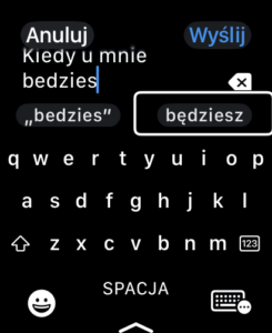 Okno aplikacji Wiadomości na Apple Watch. Tło jest czarne, a tekst jest biały. W polu tekstowym wpis Kiedy u mnie będziesz